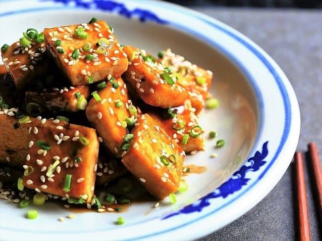 crispy tofu on a plate with sesame seeds